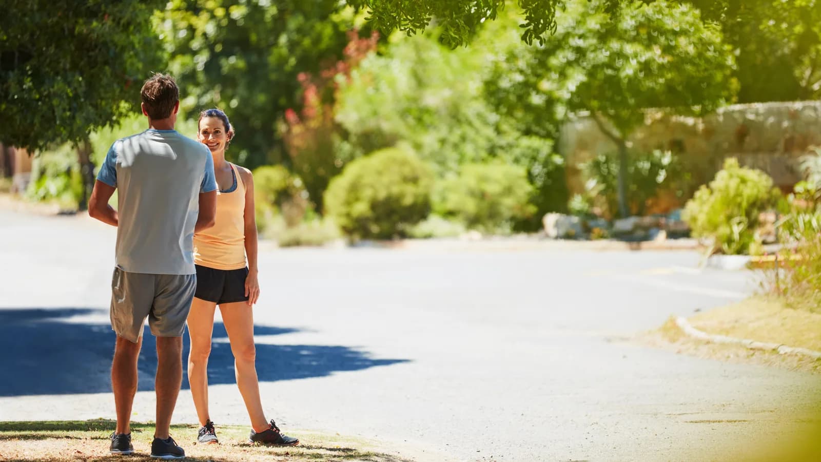 Dos deportistas comparten un paseo marítimo, una caminando con paso vivo y otra corriendo de forma relajada