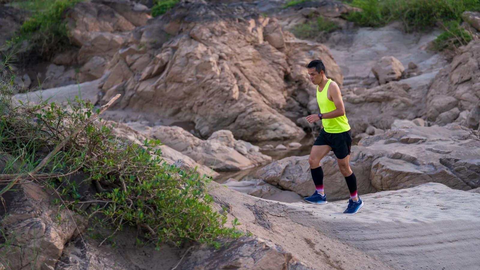 Una corredora alterna carrera y caminata en varias subidas progresivas de un sendero ancho de montaña